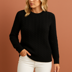 Women’s knitted sweater in black with classic cable design, soft and comfortable for casual and elegant winter outfits.
