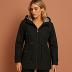 Women’s long waterproof raincoat in black with hood, breathable and stylish for rainy days.